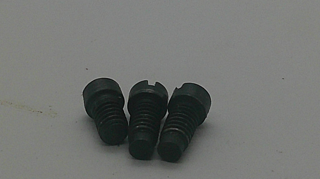 Three small black plastic threaded inserts or screws with a split tab design on one piece, arranged on a plain light gray surface.