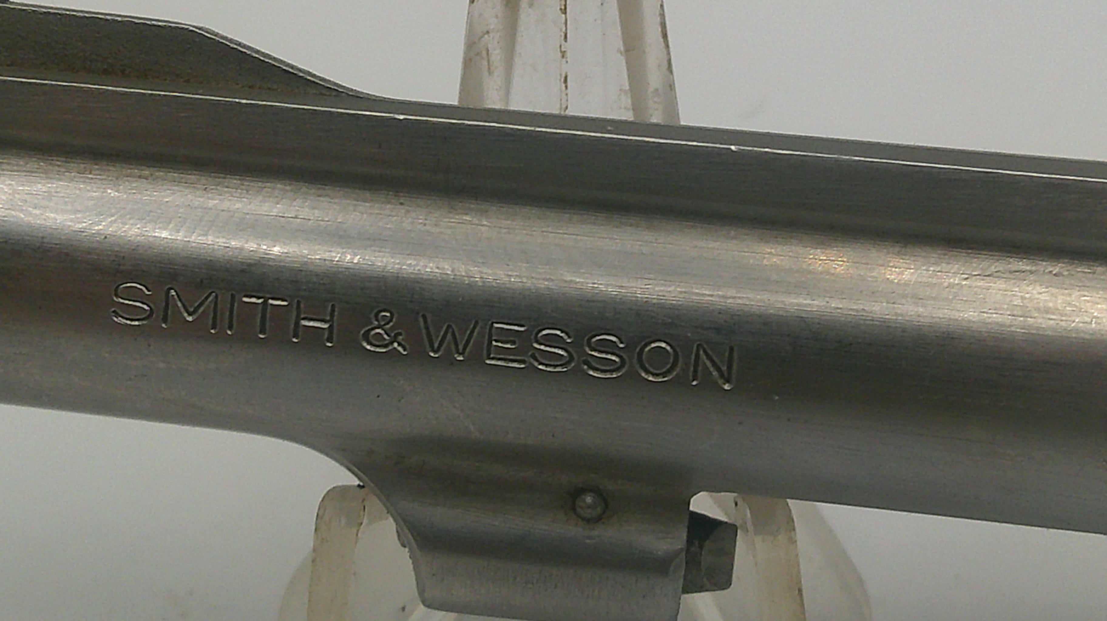 Metallic gun barrel with 'Smith & Wesson' engraving on a white background
