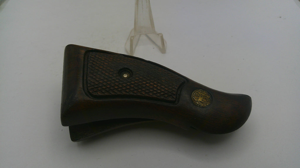 Brown leather gun holster with gold emblem on a white background