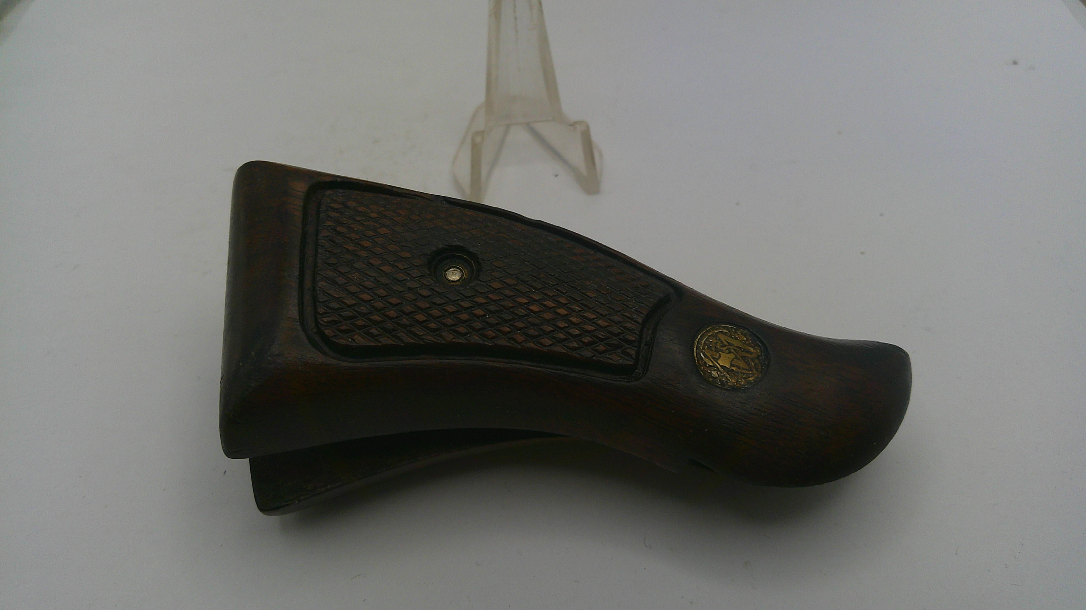 Brown leather gun holster with gold emblem on a white background