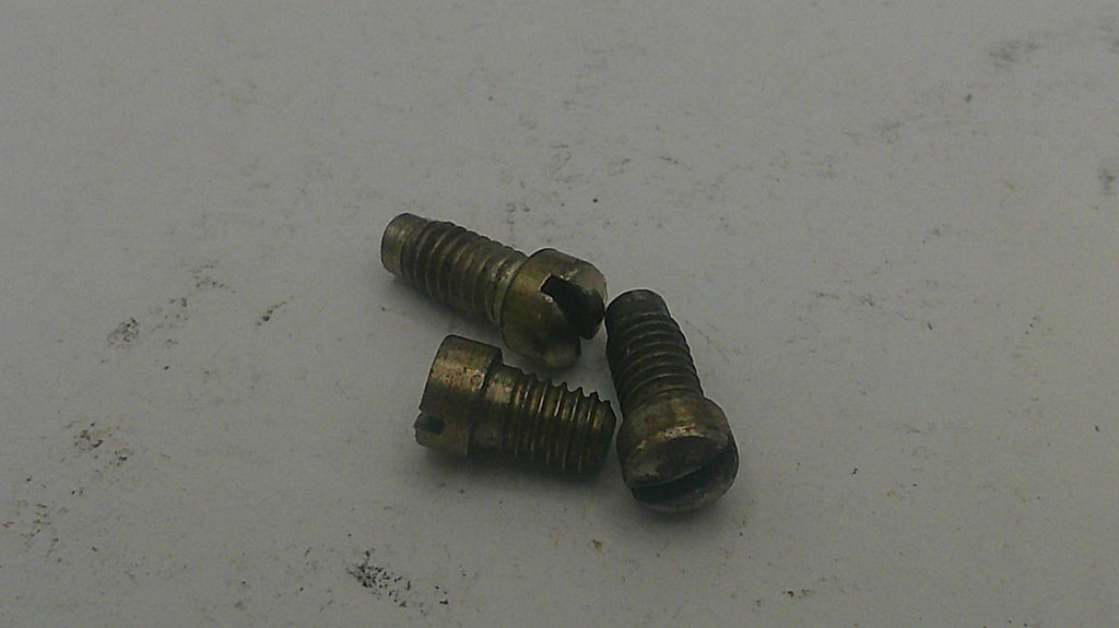 Three brass screws on a light gray background