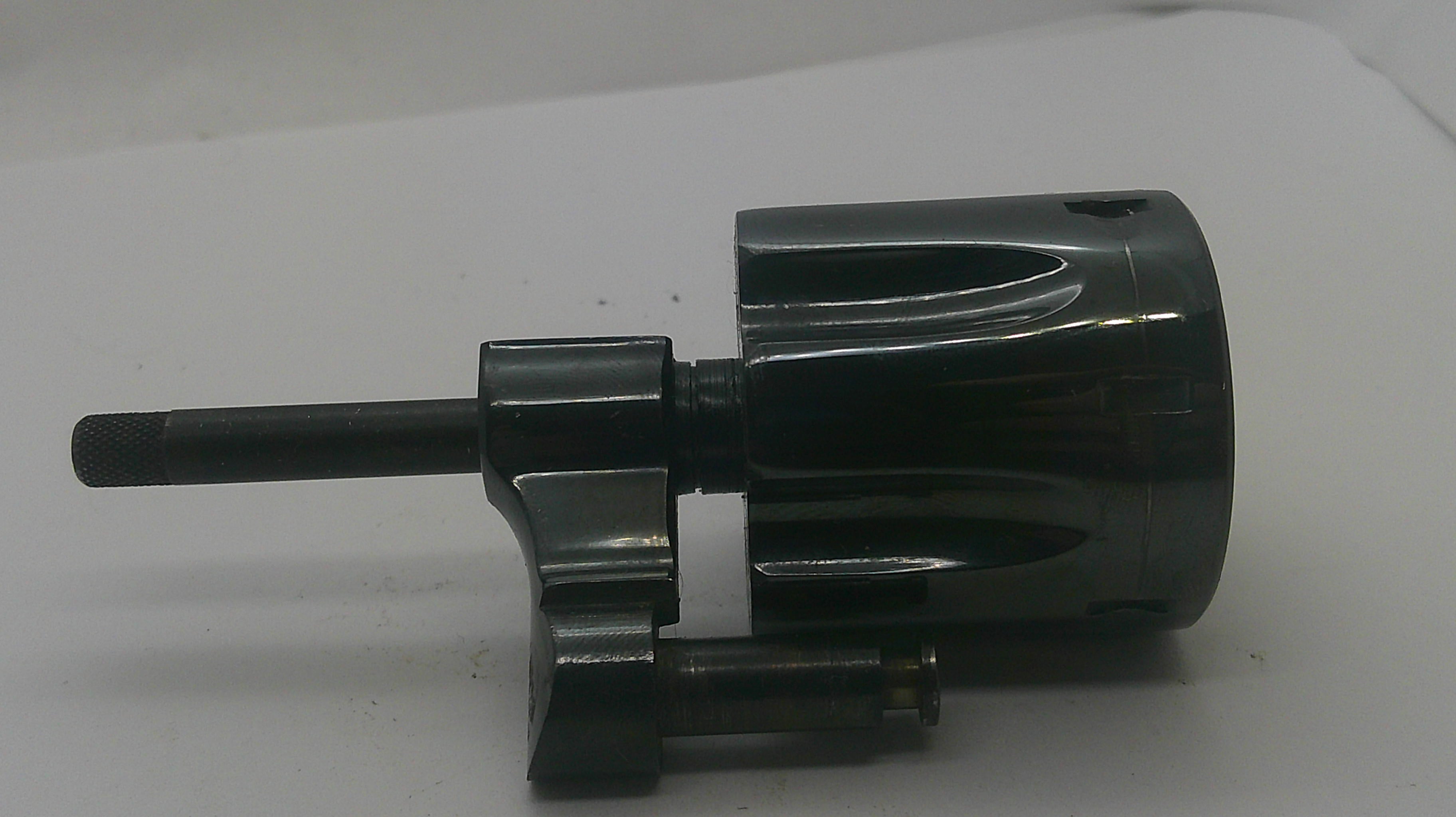 A black metal mechanical component with a cylindrical body, a protruding shaft, and a small attached rod, photographed on a plain light background.