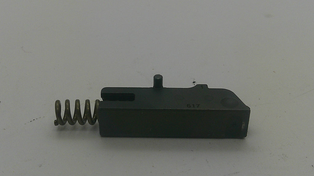 A black metal and spring trigger component, likely a firearm safety part, photographed on a plain light gray background.