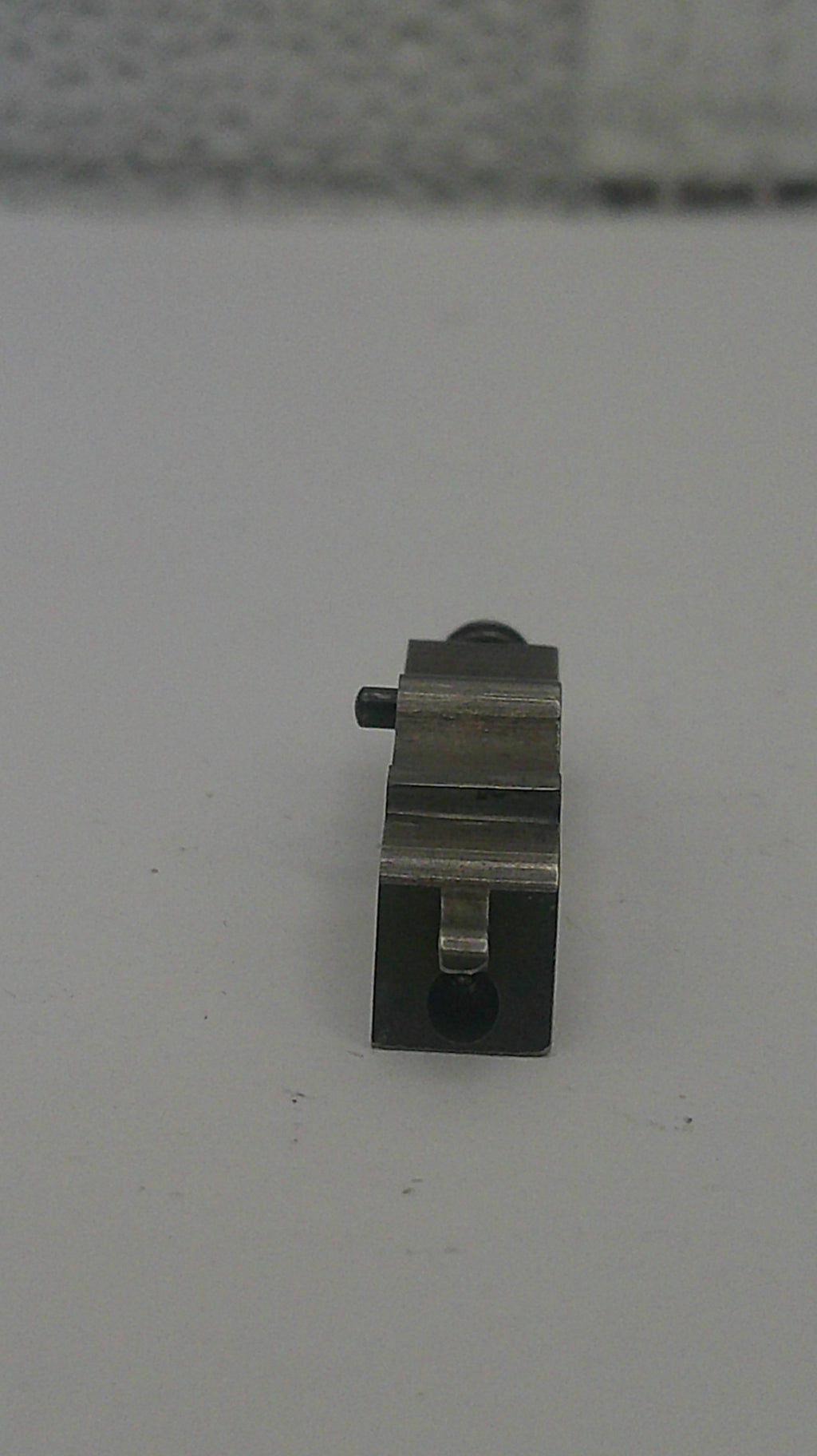 Small metallic object on a white background