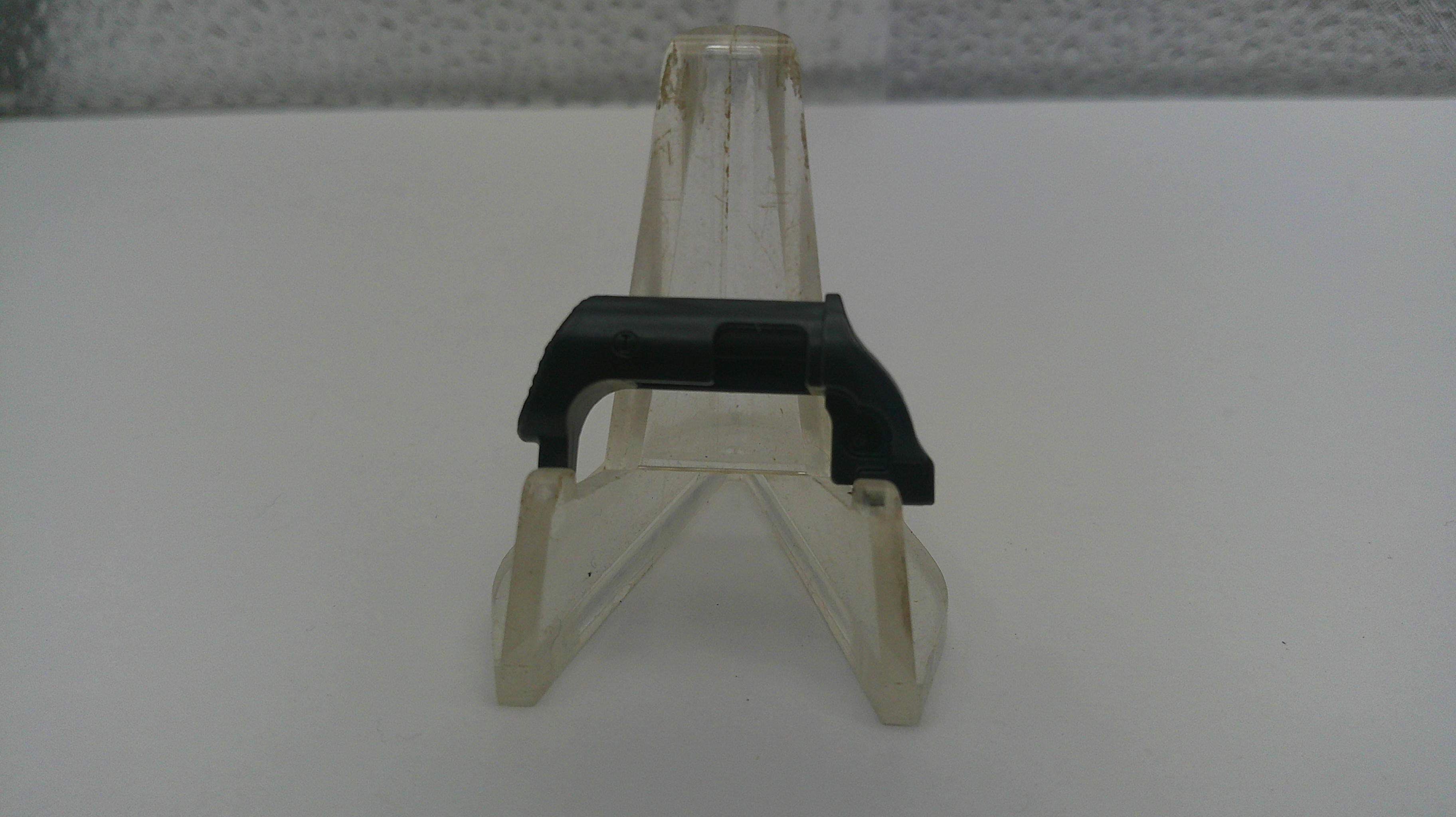 Small clear plastic stand with black base on a white surface