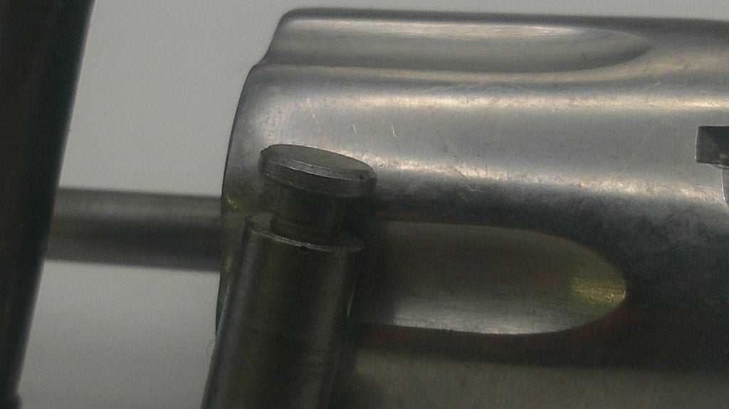 Close-up of a metal component with a bolt on a gray background