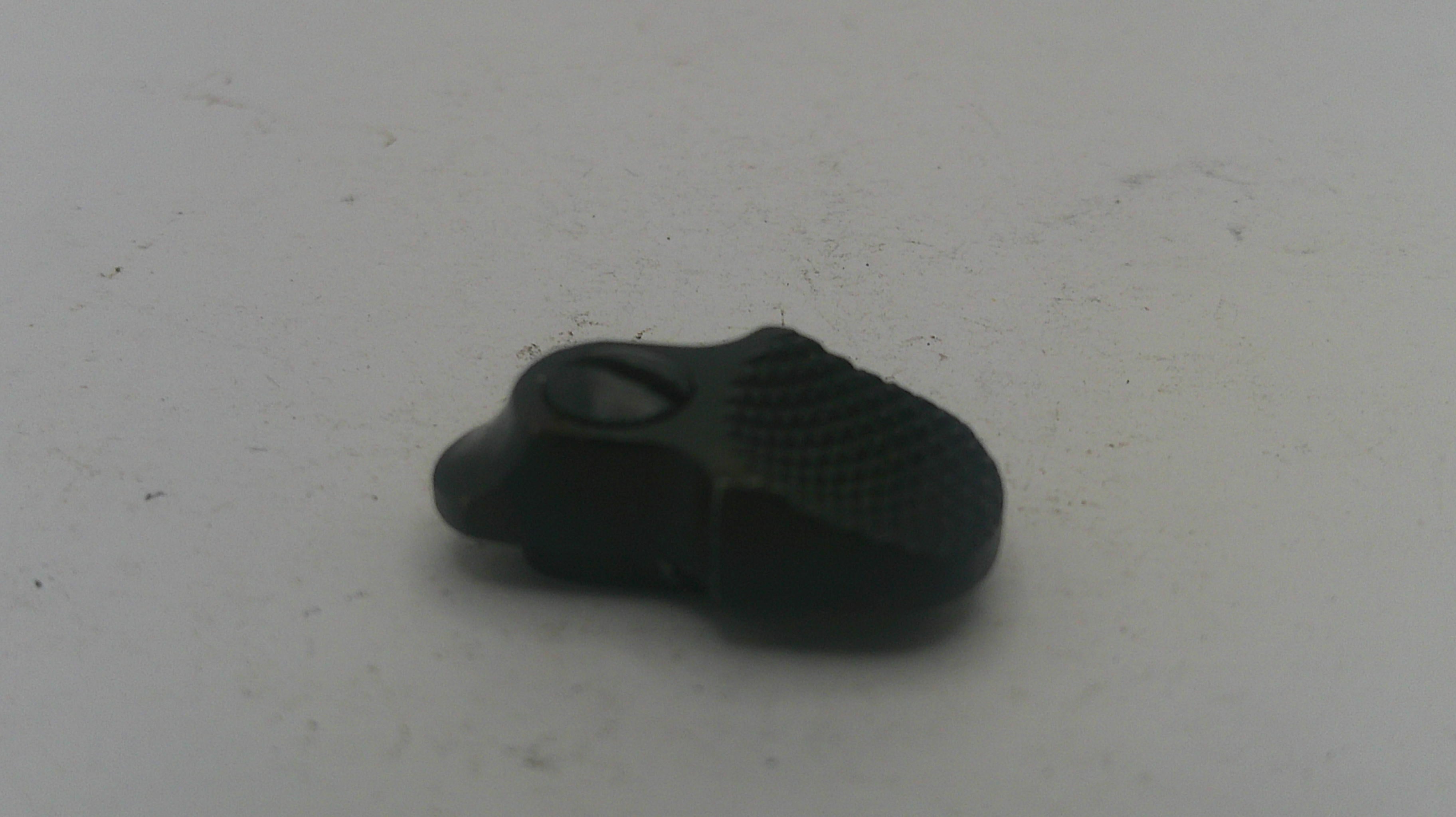 Black rubber duck on a white textured surface