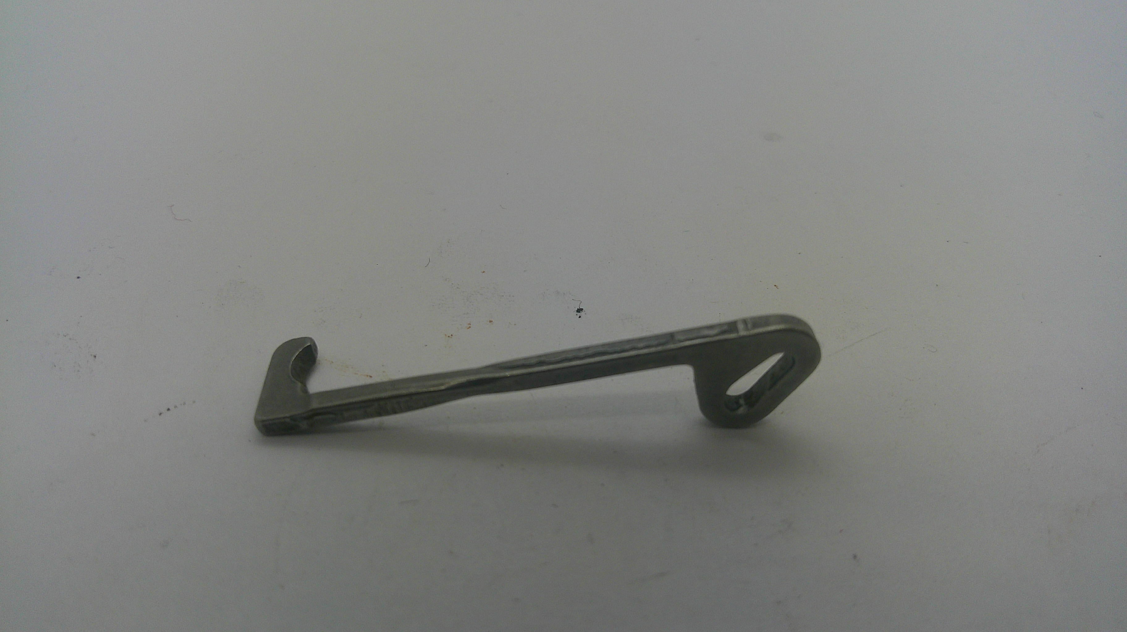 A small metal latch or bracket with a looped end, photographed on a plain light gray surface.
