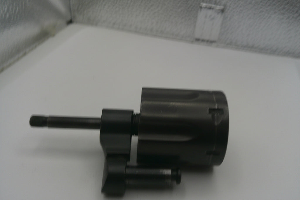 Black mechanical component on a white surface with a textured background