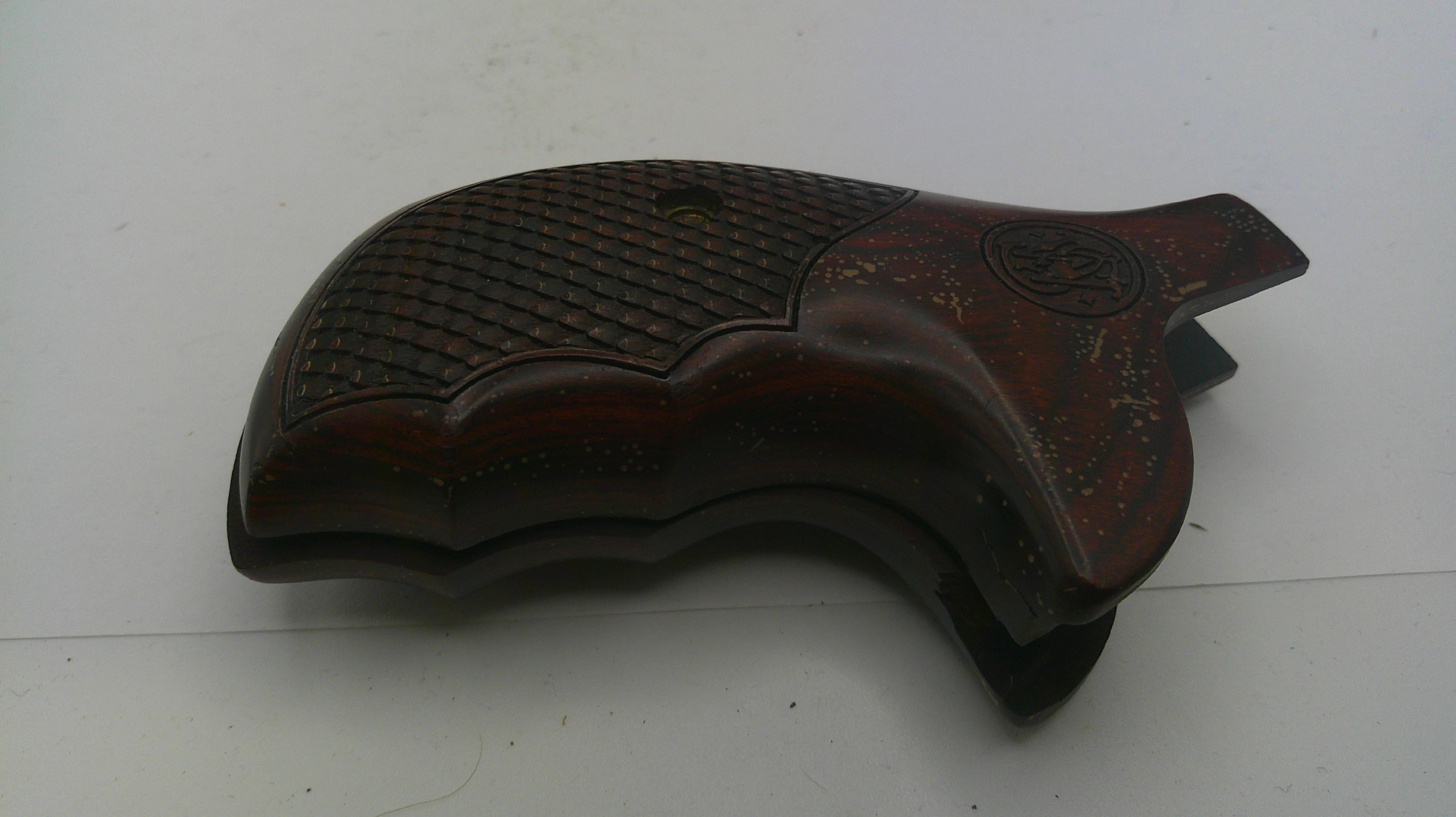 Wooden gun stock with intricate carvings on a white background