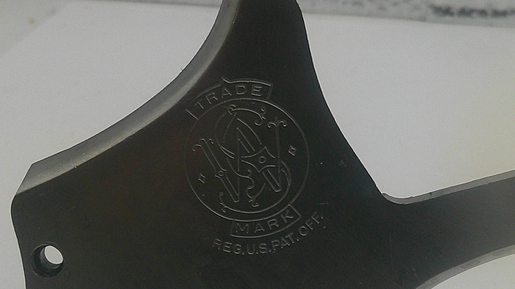 Black metal component with a logo and text on a white background