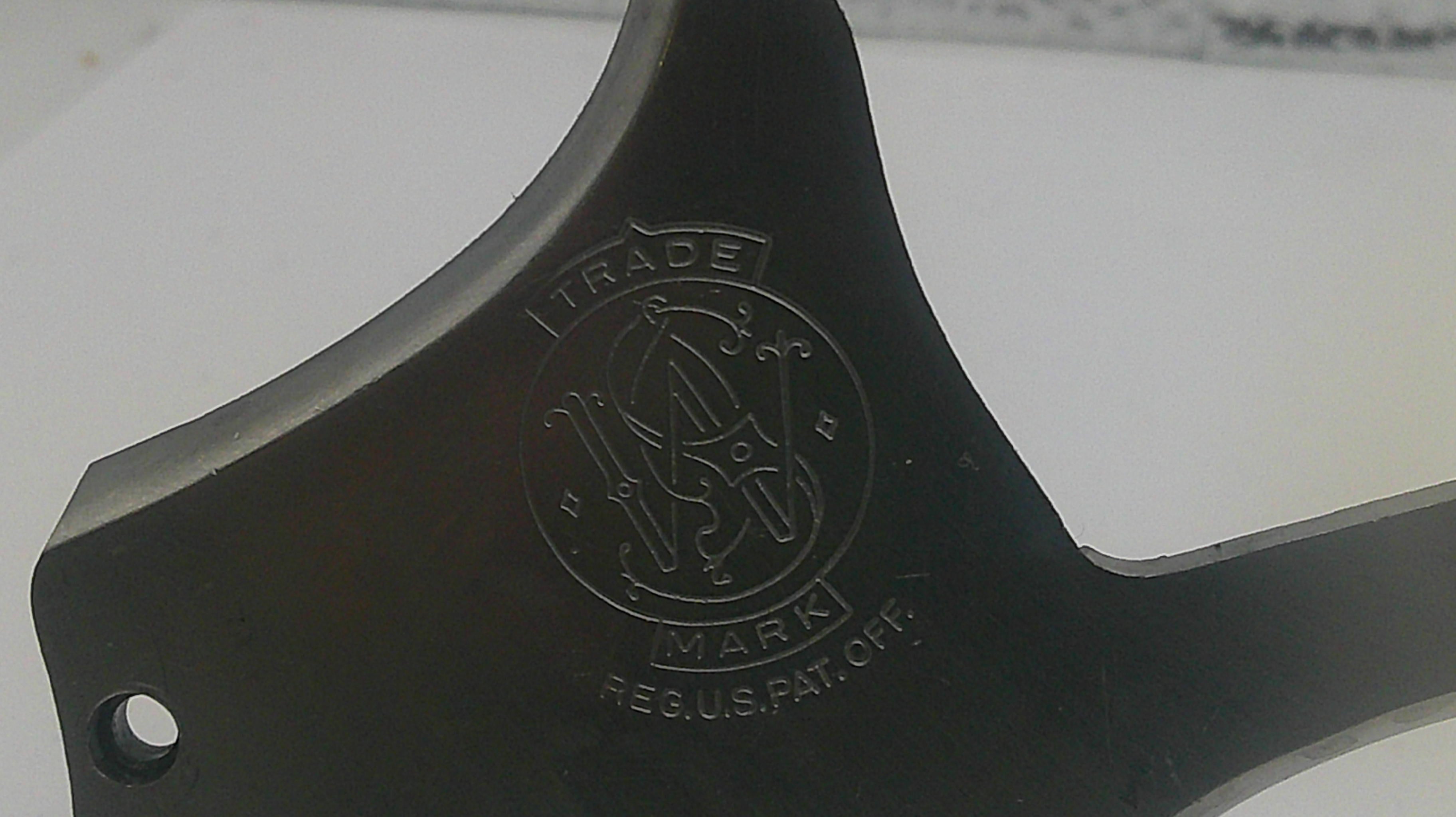 Black metal component with a logo and text on a white background