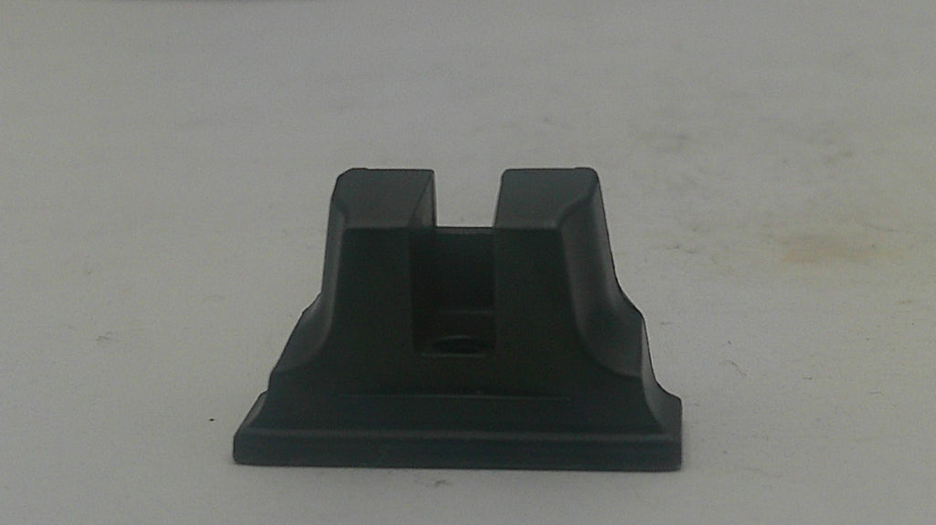A black plastic or rubber mounting bracket or adapter piece with a rectangular base and two upright flanges, shown on a plain off-white surface.