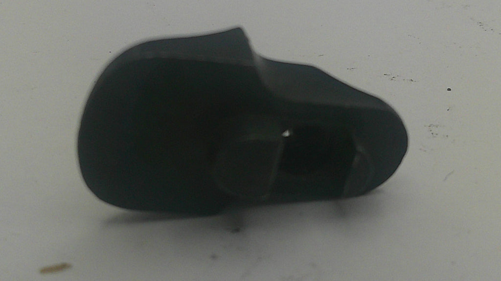 A small black plastic component or cap with a rounded, tapered shape, shown on a plain off-white surface.