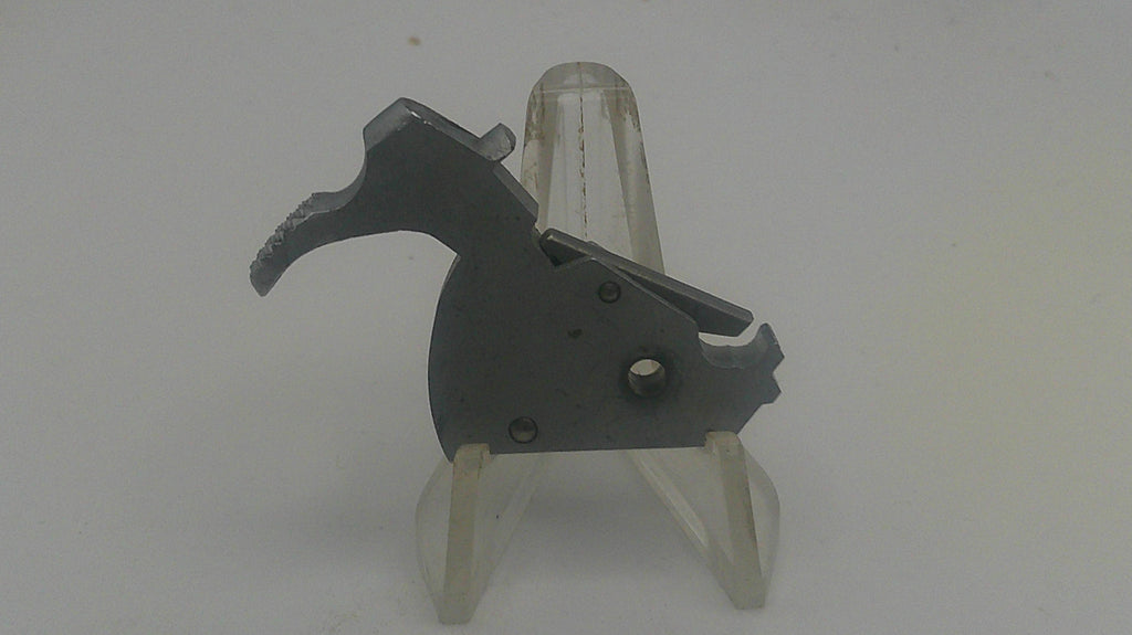 Black metal component on a white stand against a white background