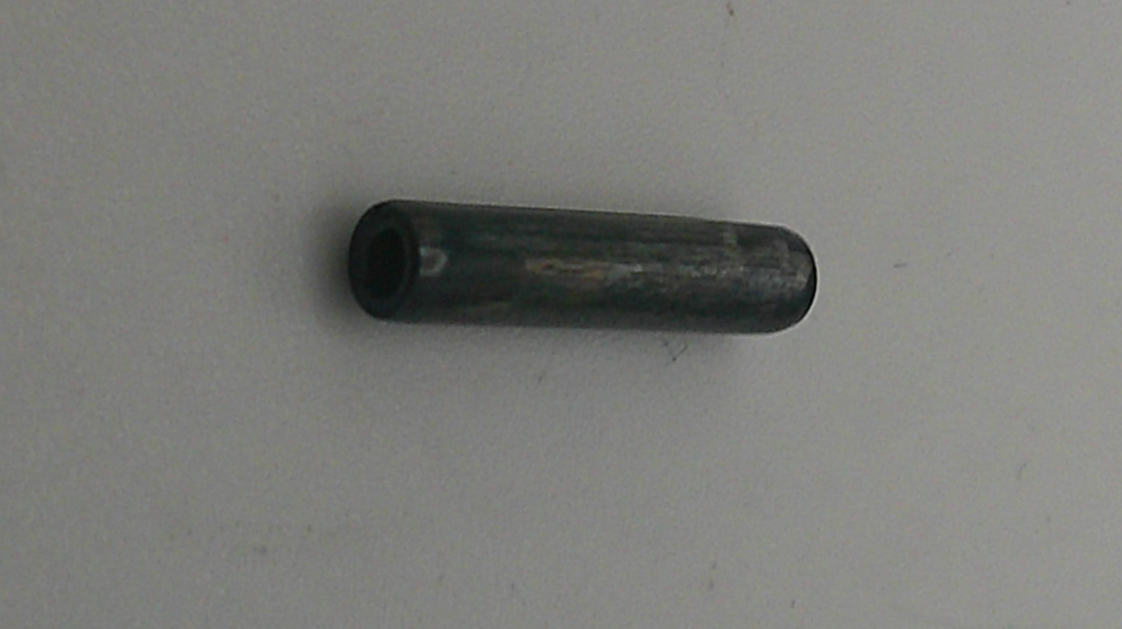 Metallic cylindrical object on a light gray background