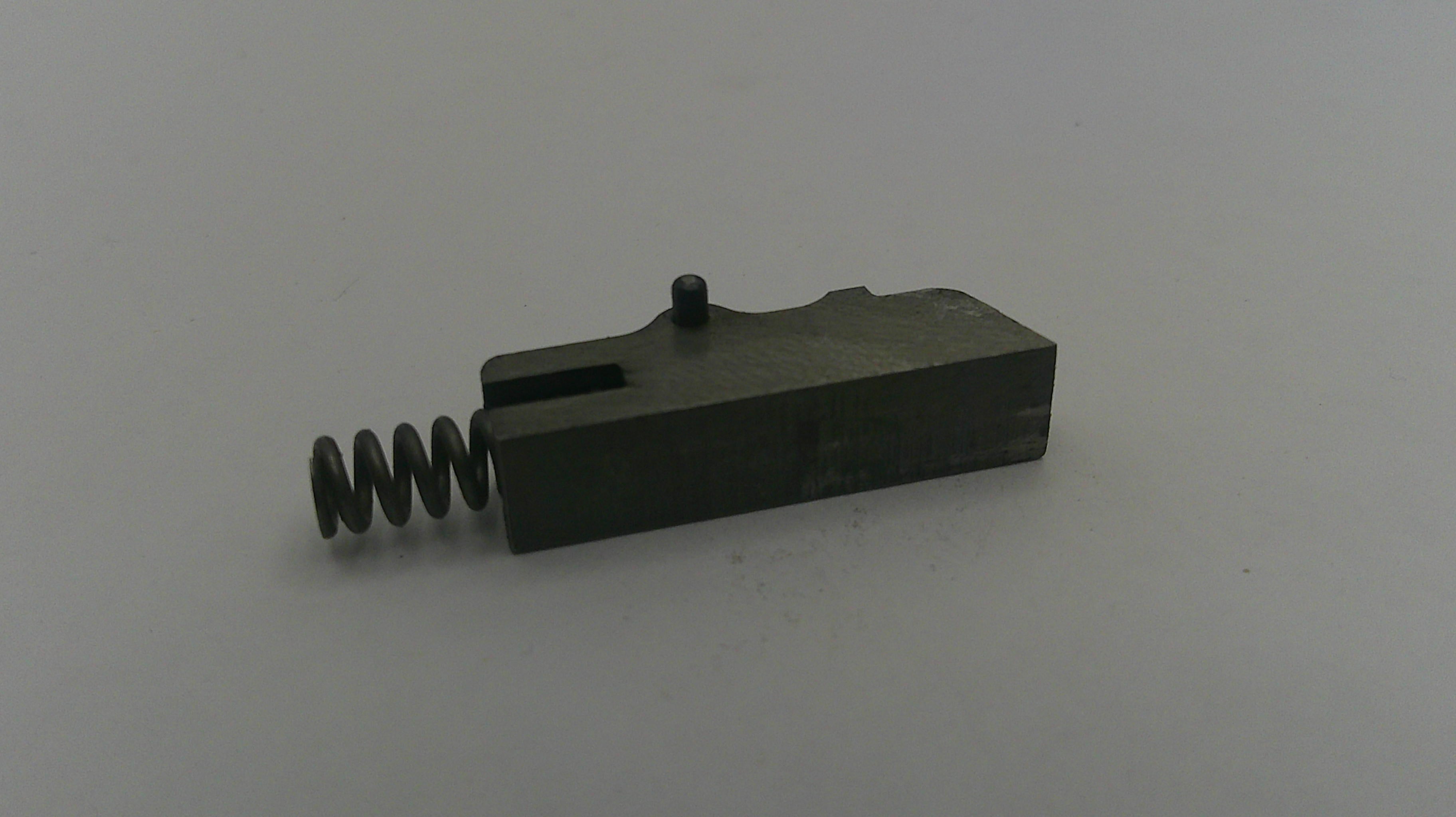 Black metal component with a spring on a white background