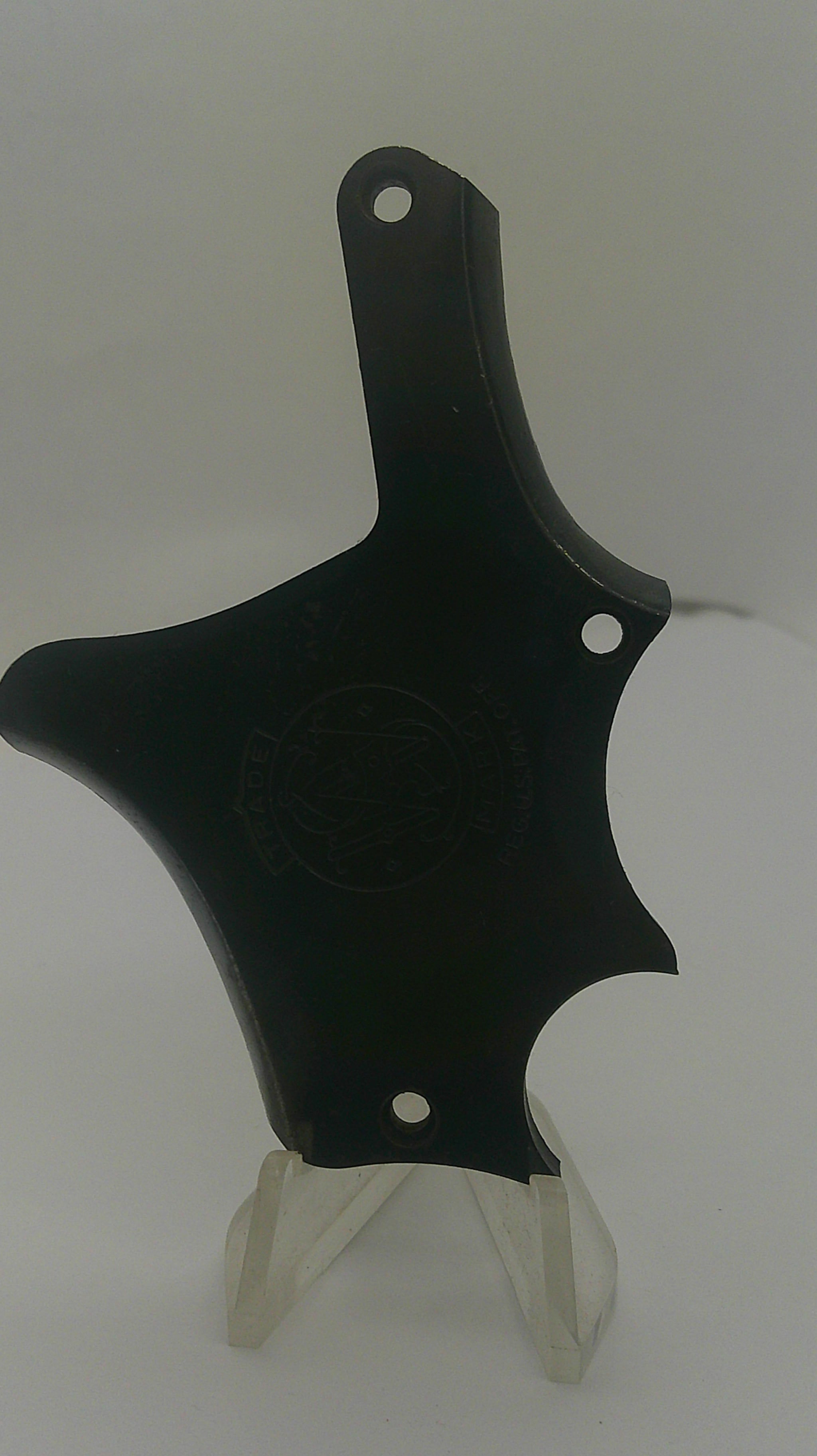 A black plastic replacement part with a wing-like shape and two small white tabs extending from the left side, shown against a plain light background.