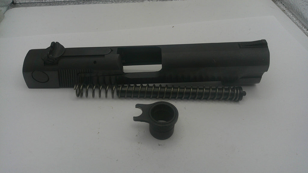 Black gun slide and spring on a white surface