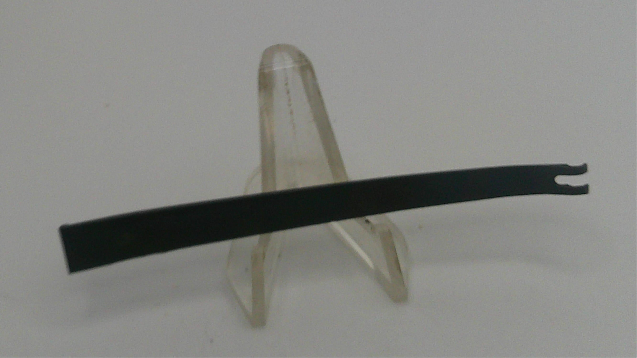 Black tool on a clear stand against a white background