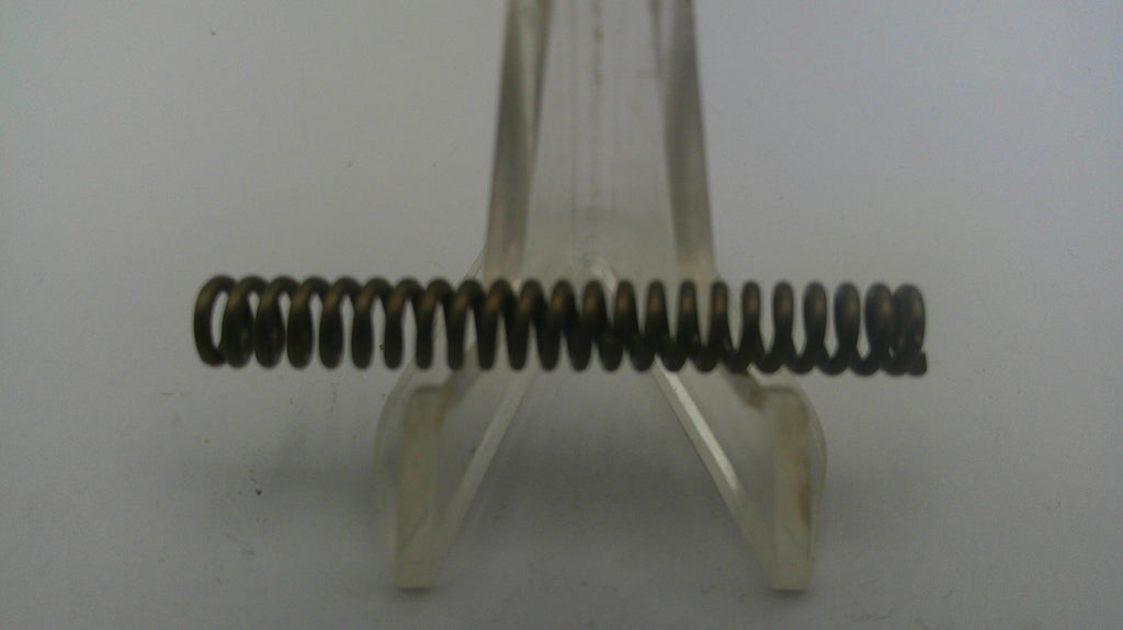 Metal spring on a clear stand against a white background