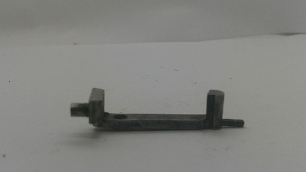 A small dark metal hardware piece with a flat rectangular bar, a left-side bolt protrusion, and a right-side bracket with a protruding bolt, shown on a plain light background.