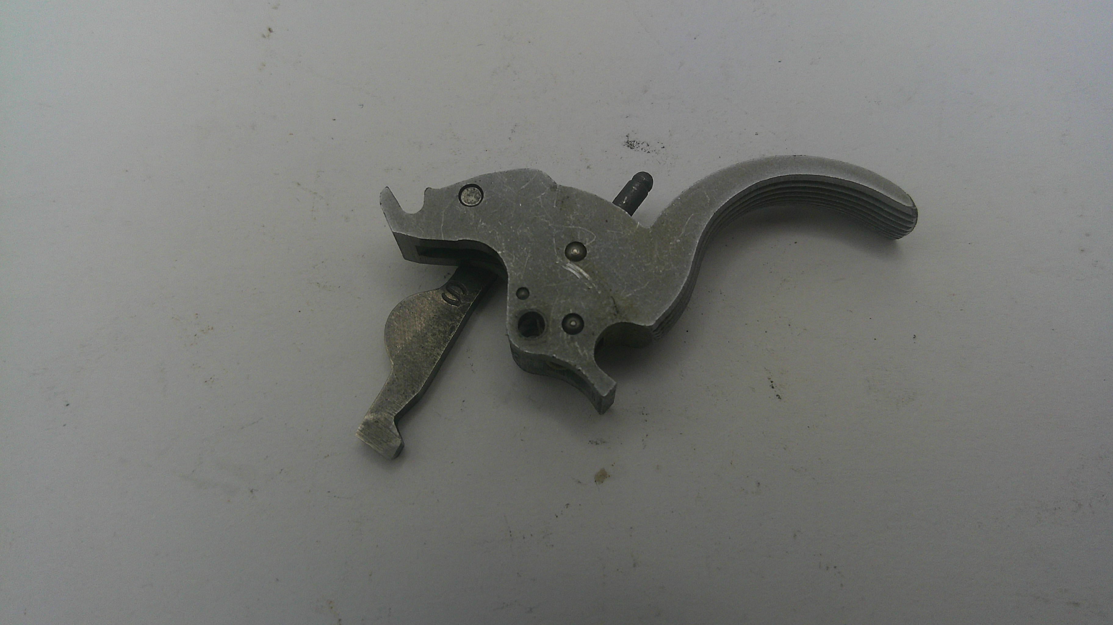 Metallic gun trigger on a white background