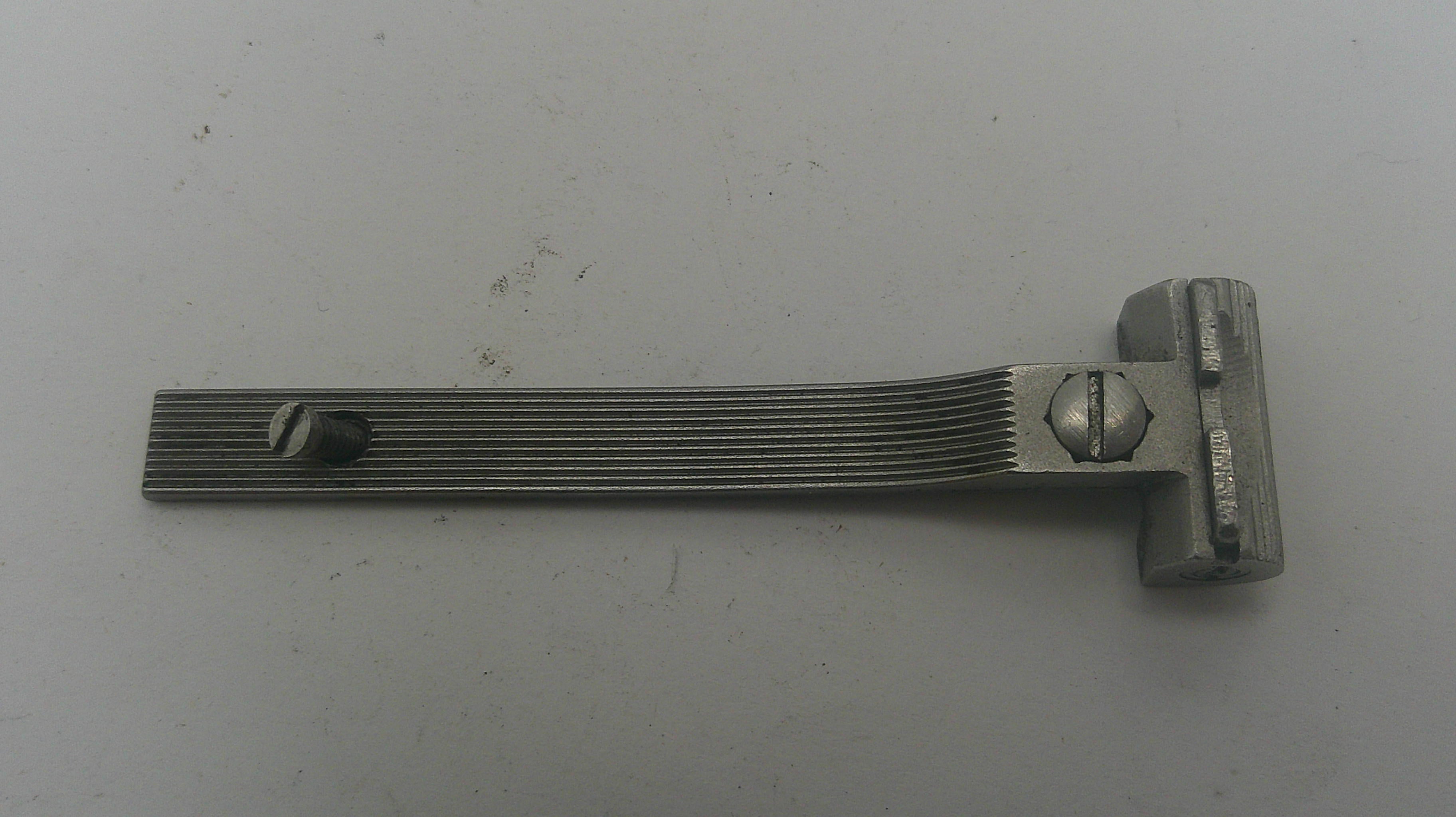 Metallic tool with a textured handle on a gray background