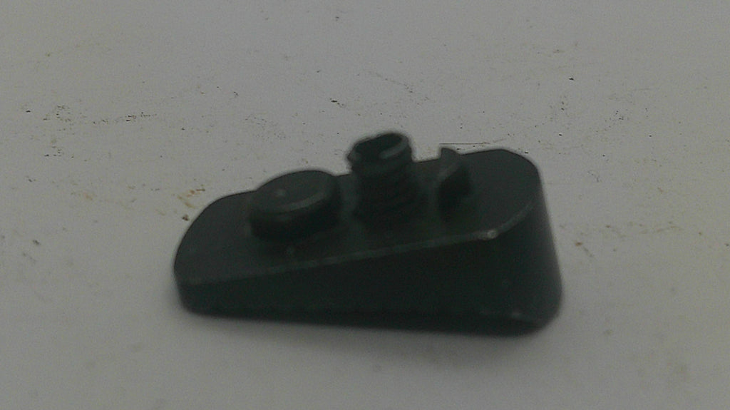 A small black plastic component with a threaded hole and a circular protruding tab, photographed on a plain off-white surface.