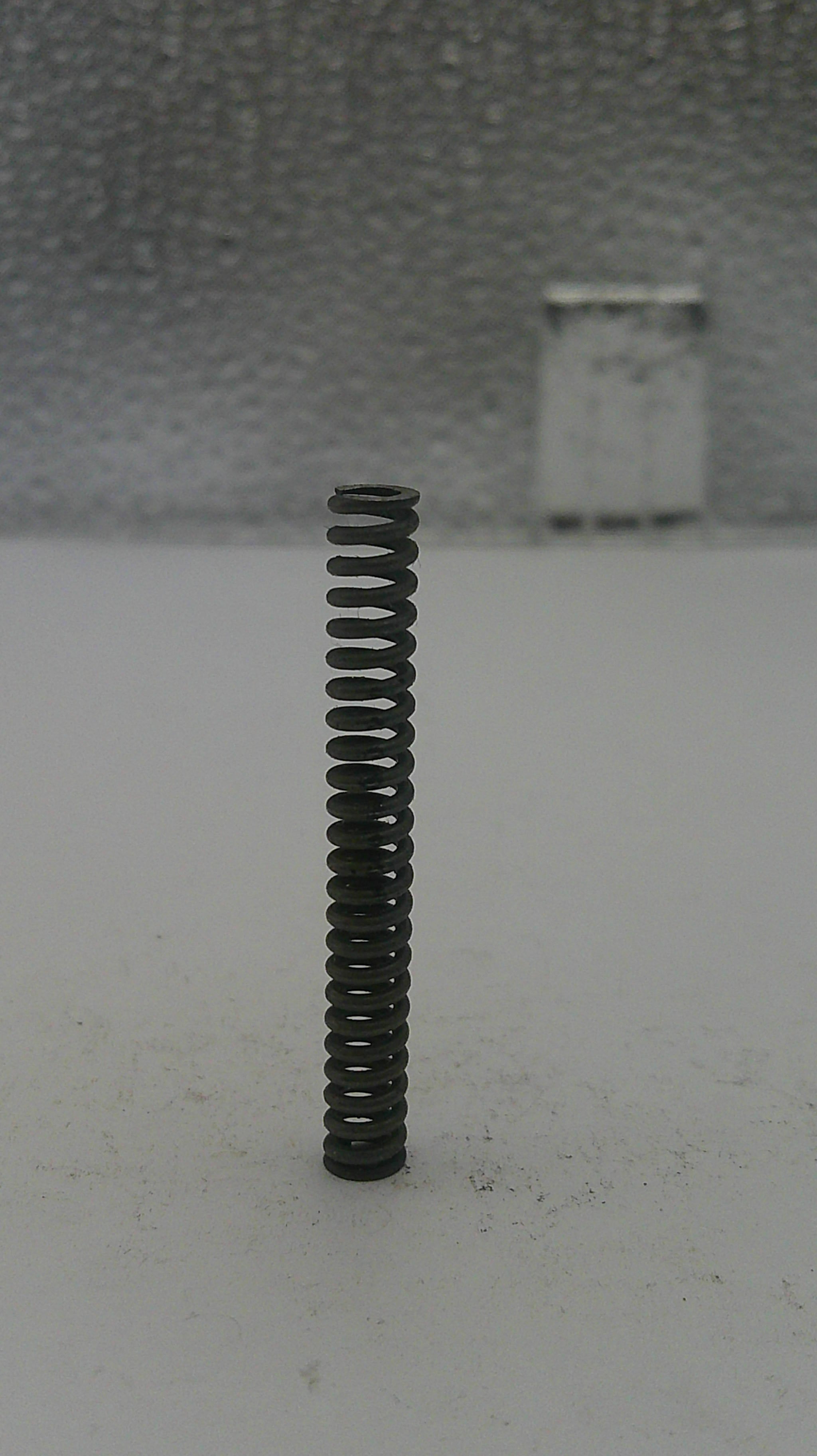 Black spring on a textured gray surface