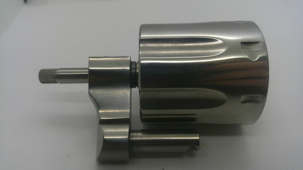 A metallic cylindrical mechanical component with a polished silver finish, featuring a threaded shaft and a small attached rod, photographed on a plain light background.