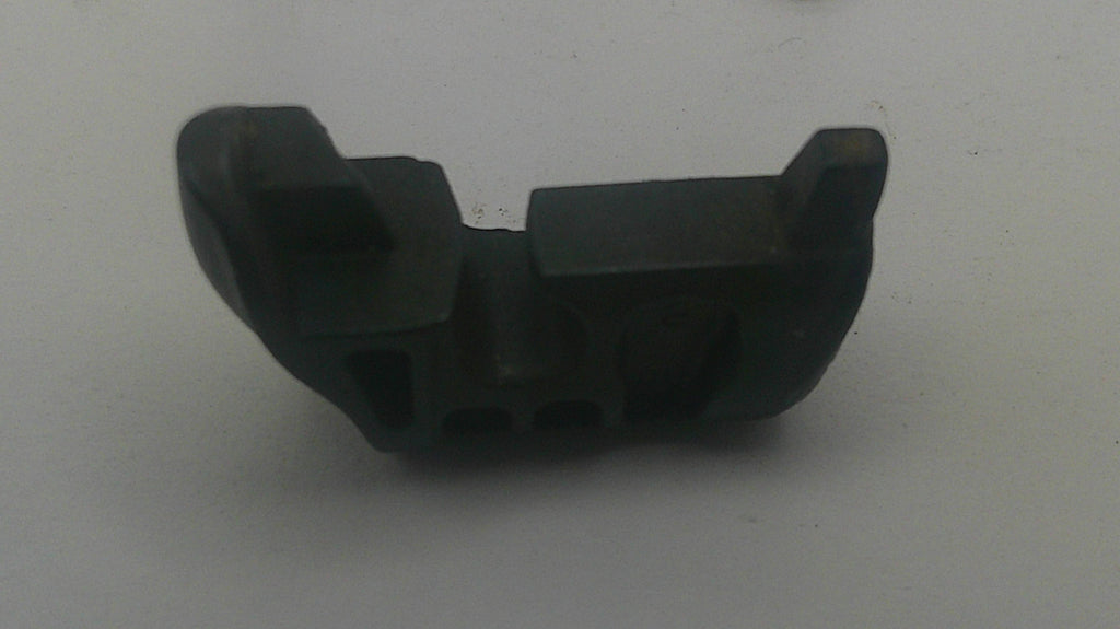 A small black plastic or rubber mechanical component with molded slots and raised tabs, photographed on a plain light gray background.