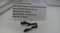 Black gun slide component with a label on a white surface