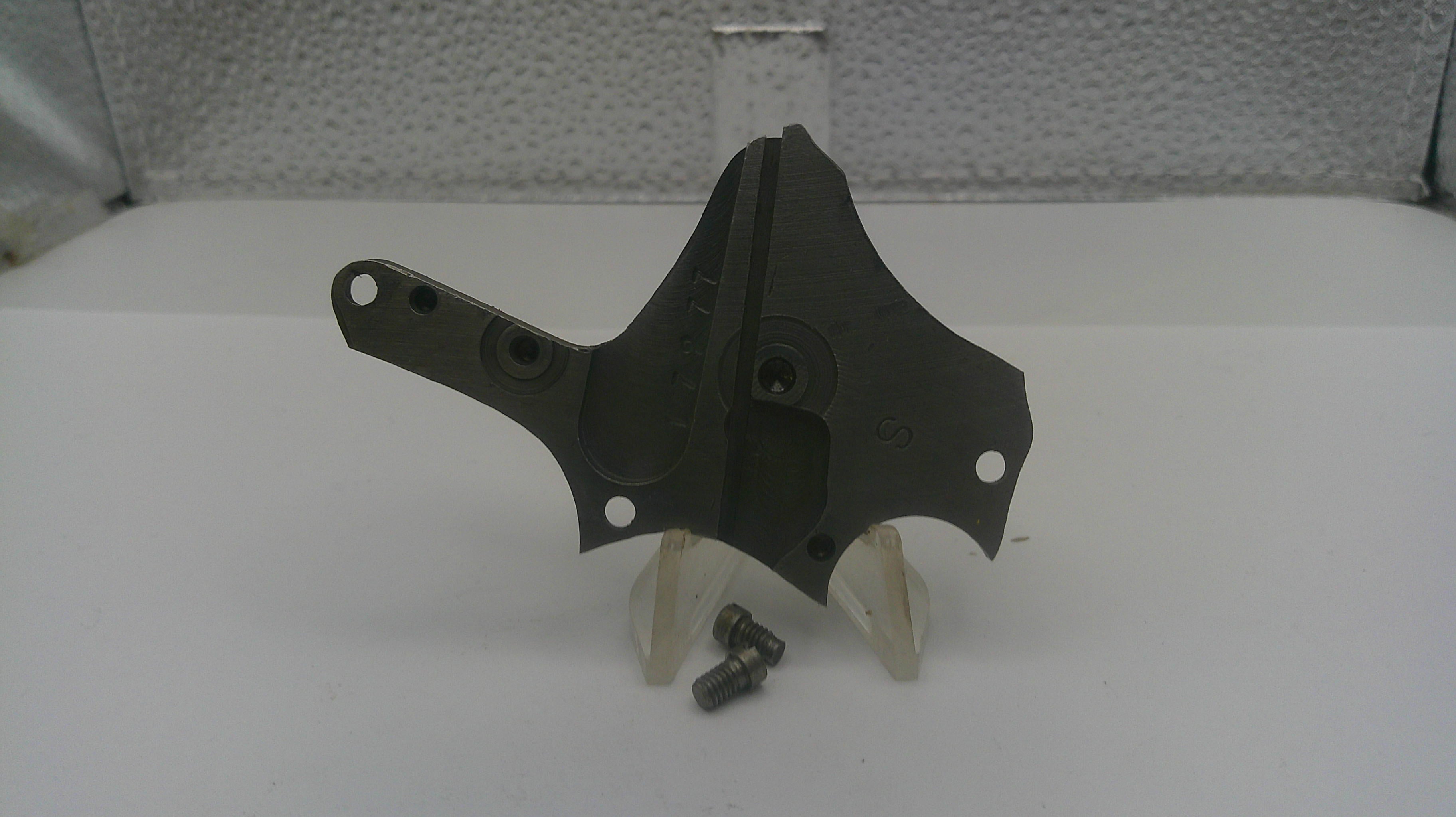 Black metal bracket with screws on a white surface