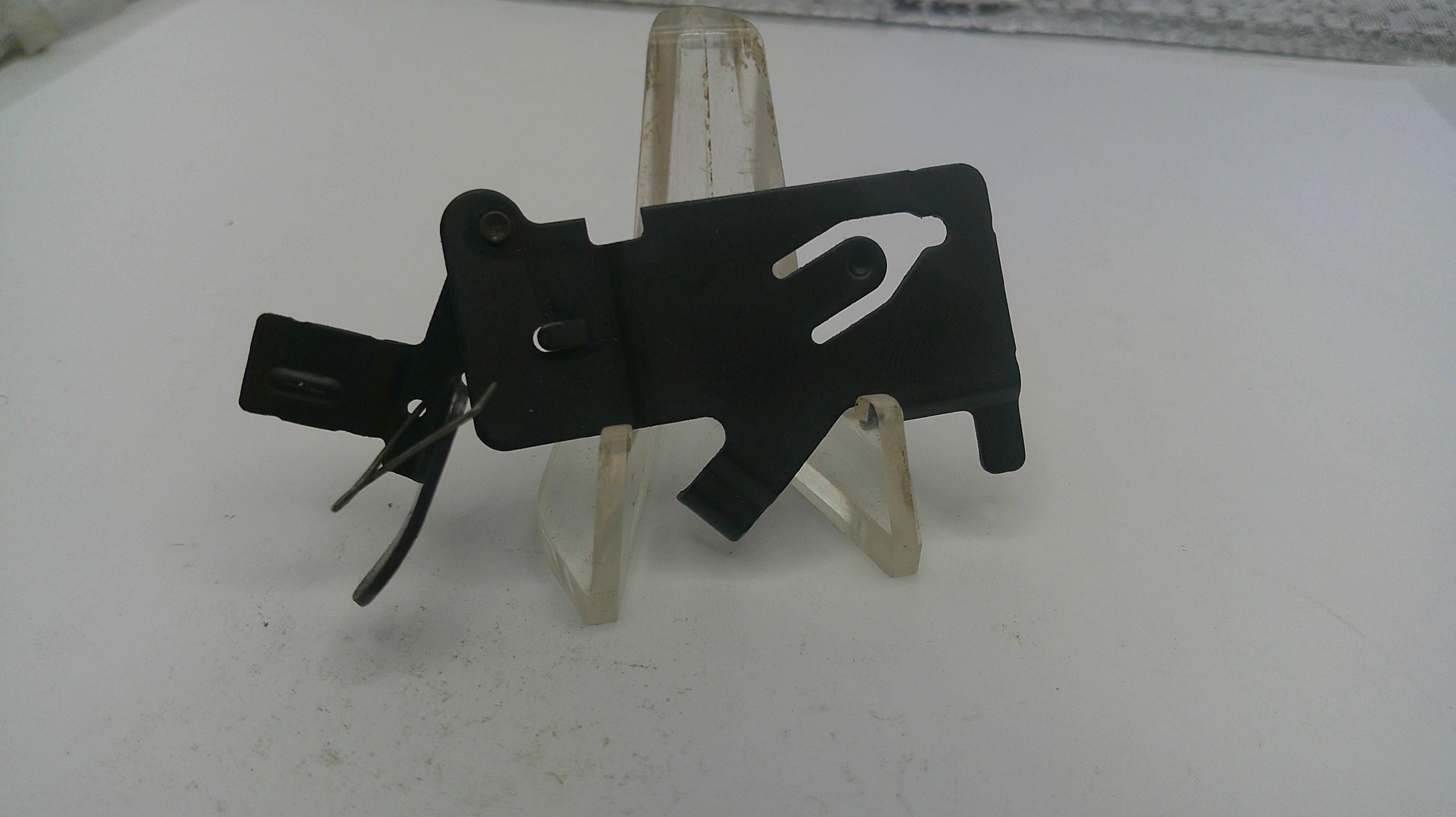 Black metal tool on a white stand with a white background
