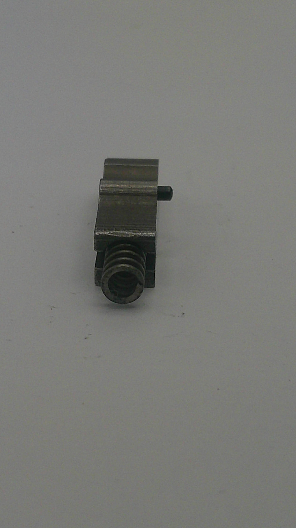 Small metallic object on a light gray background