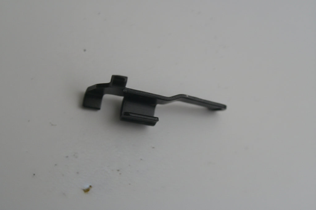 Small black metal clip on a white background