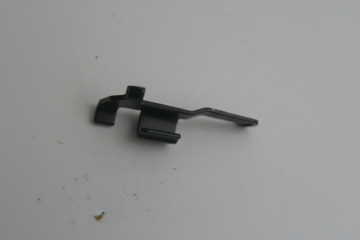 Small black metal clip on a white background