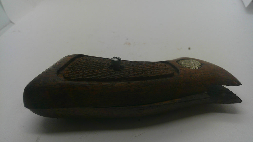 A dark brown wooden case with a textured grip pattern and a small round metallic emblem, photographed on a plain white surface.