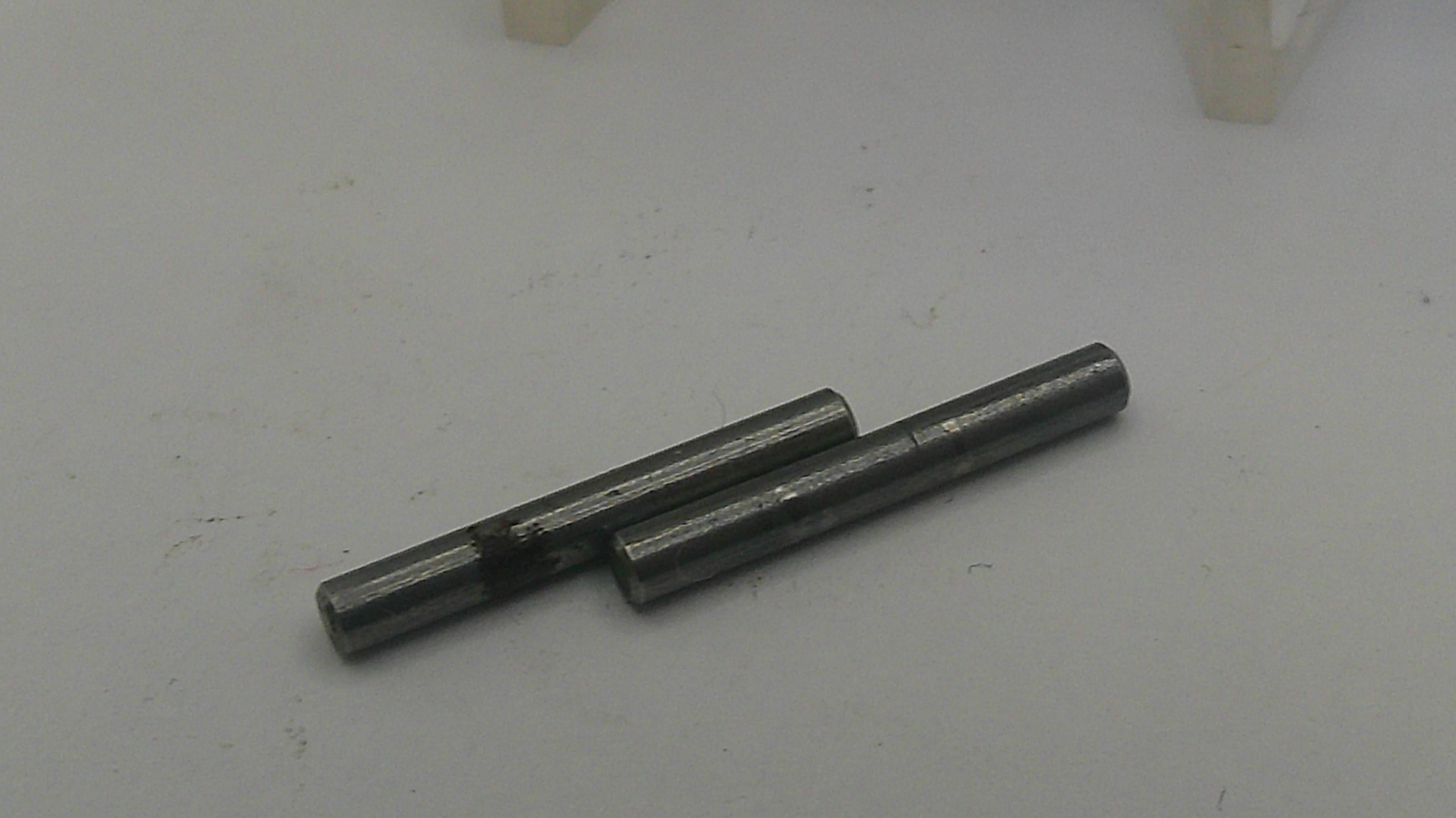 Two metallic pins on a light gray surface