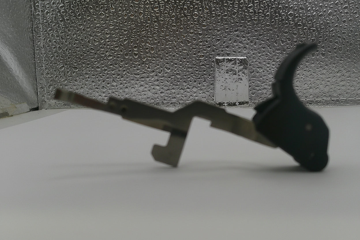 Metallic tool with a black handle on a textured surface