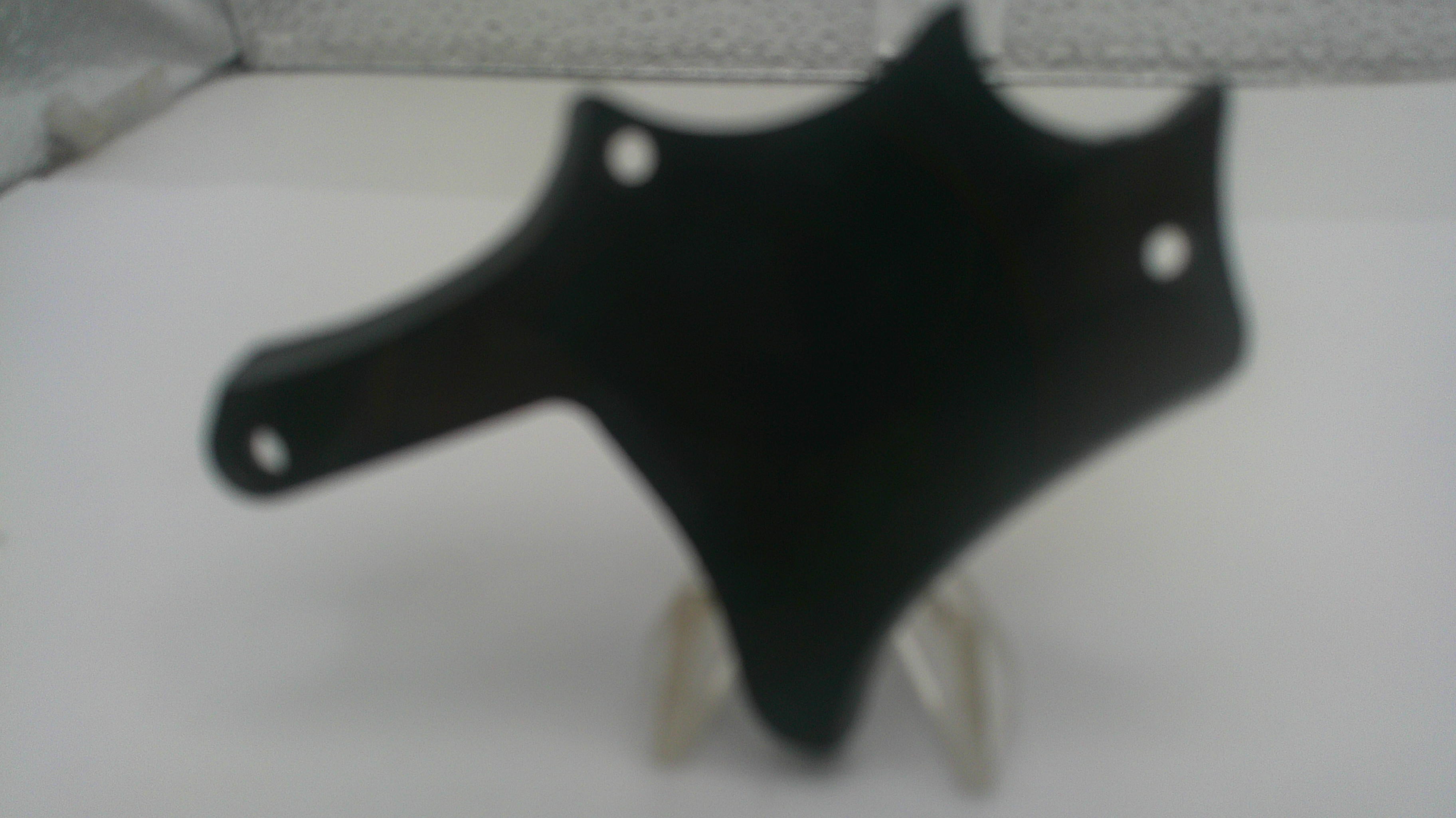 A black plastic motorcycle or scooter fairing cover with mounting holes, displayed on a clear stand against a white background.