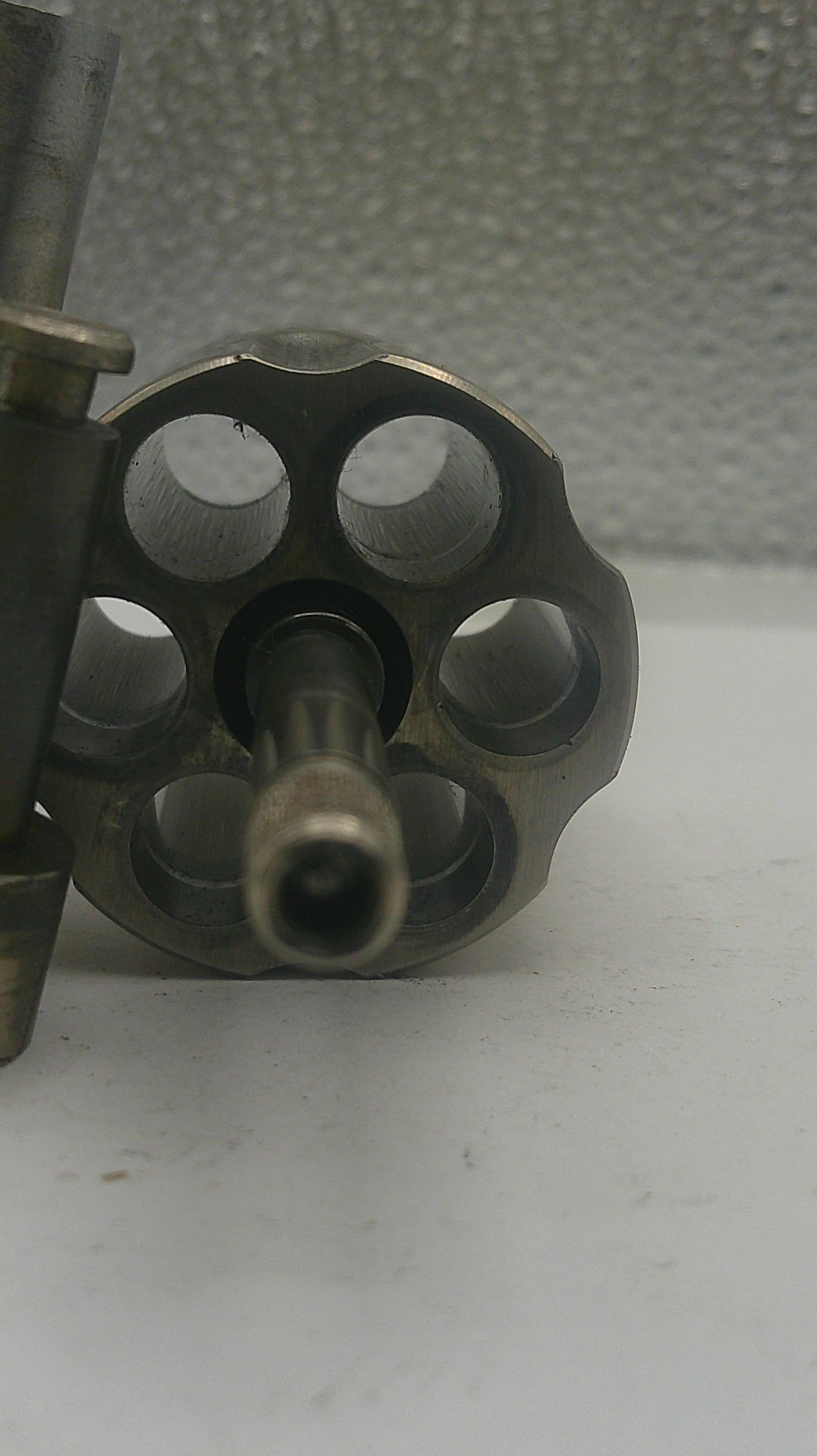 Close-up of a metallic object with circular holes on a textured surface