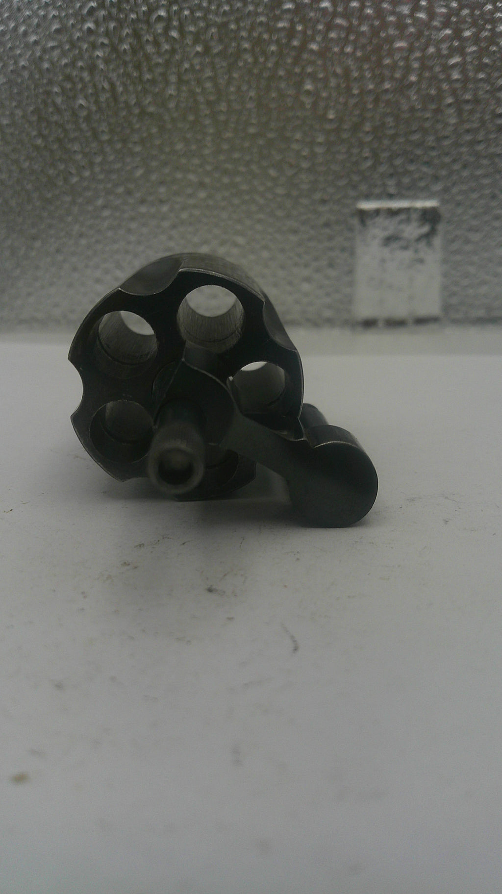 Black metal component on a textured white surface