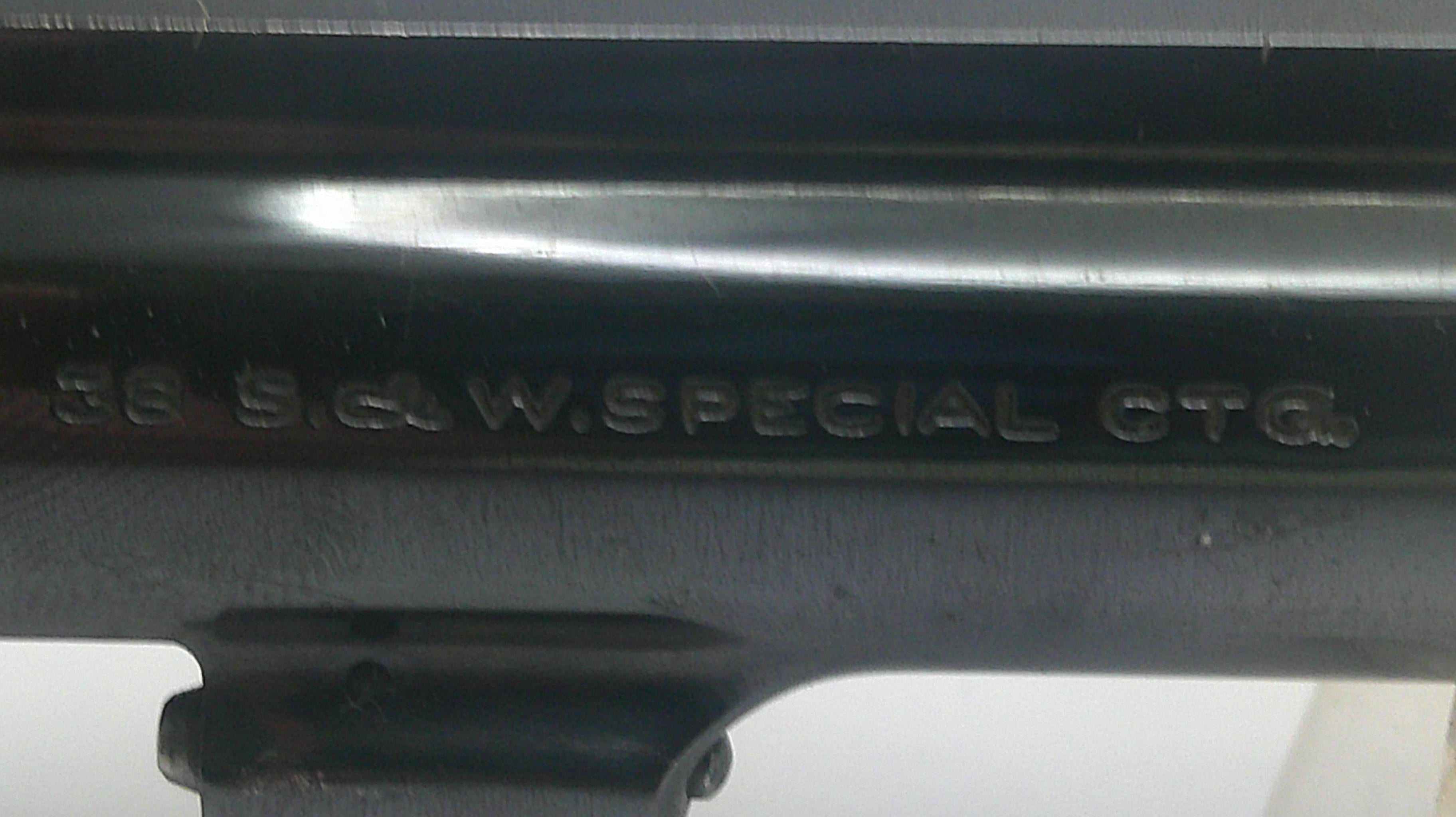 Close-up of a black metal firearm receiver with embossed text reading '56 S.G.W. SPECIAL CG6'.