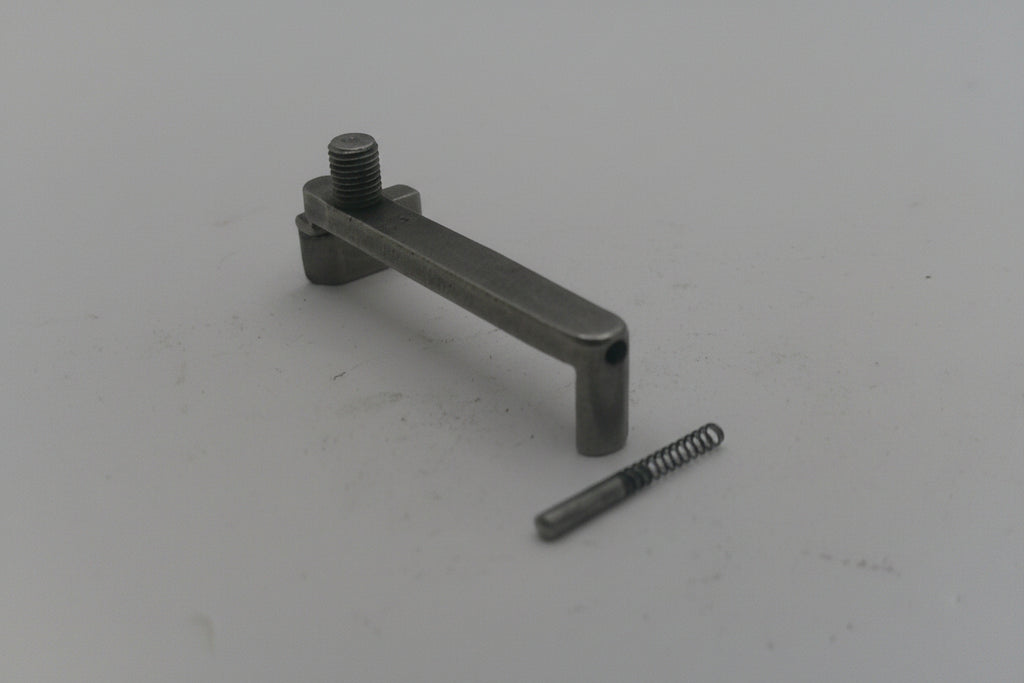 Metal lever and spring on a light gray background