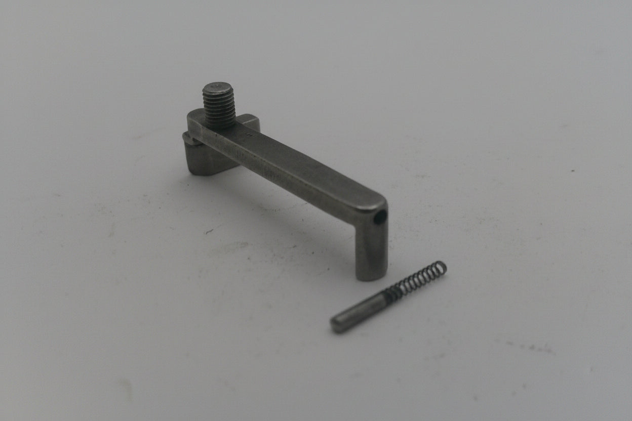 Metal lever and spring on a light gray background