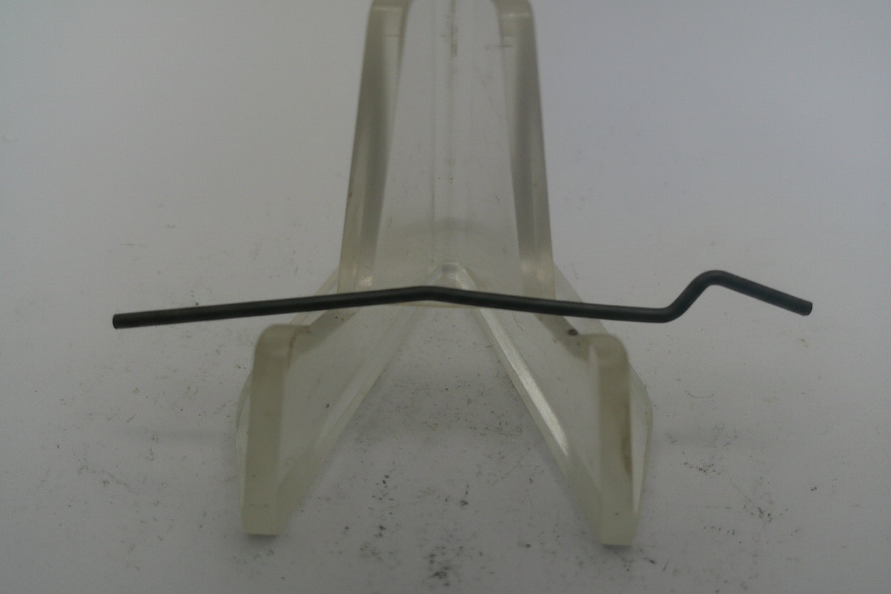 Metal rod on a white stand against a plain background