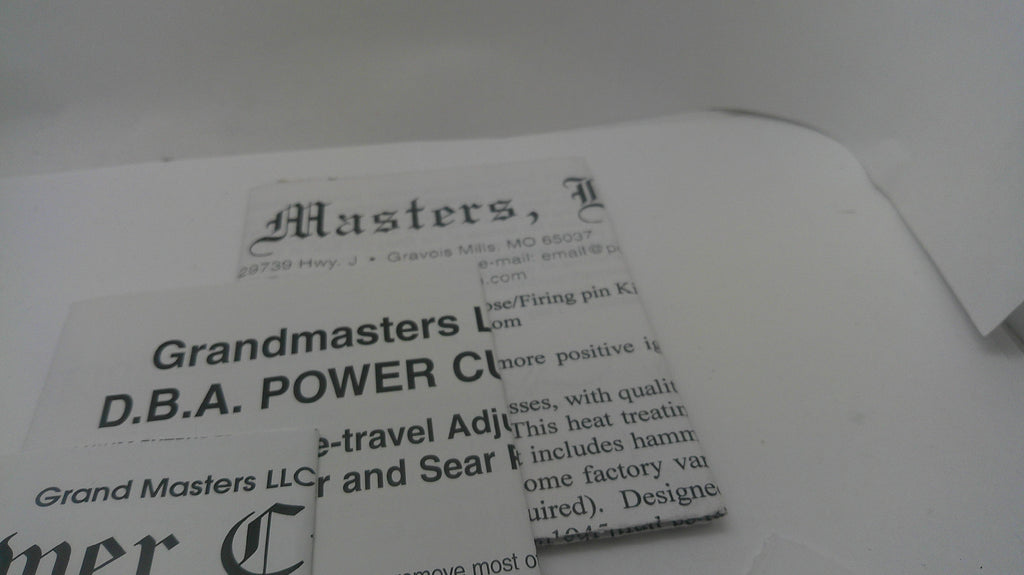 A close-up of printed paper documents or labels with visible text including 'Masters,' 'Grandmasters,' and 'D.B.