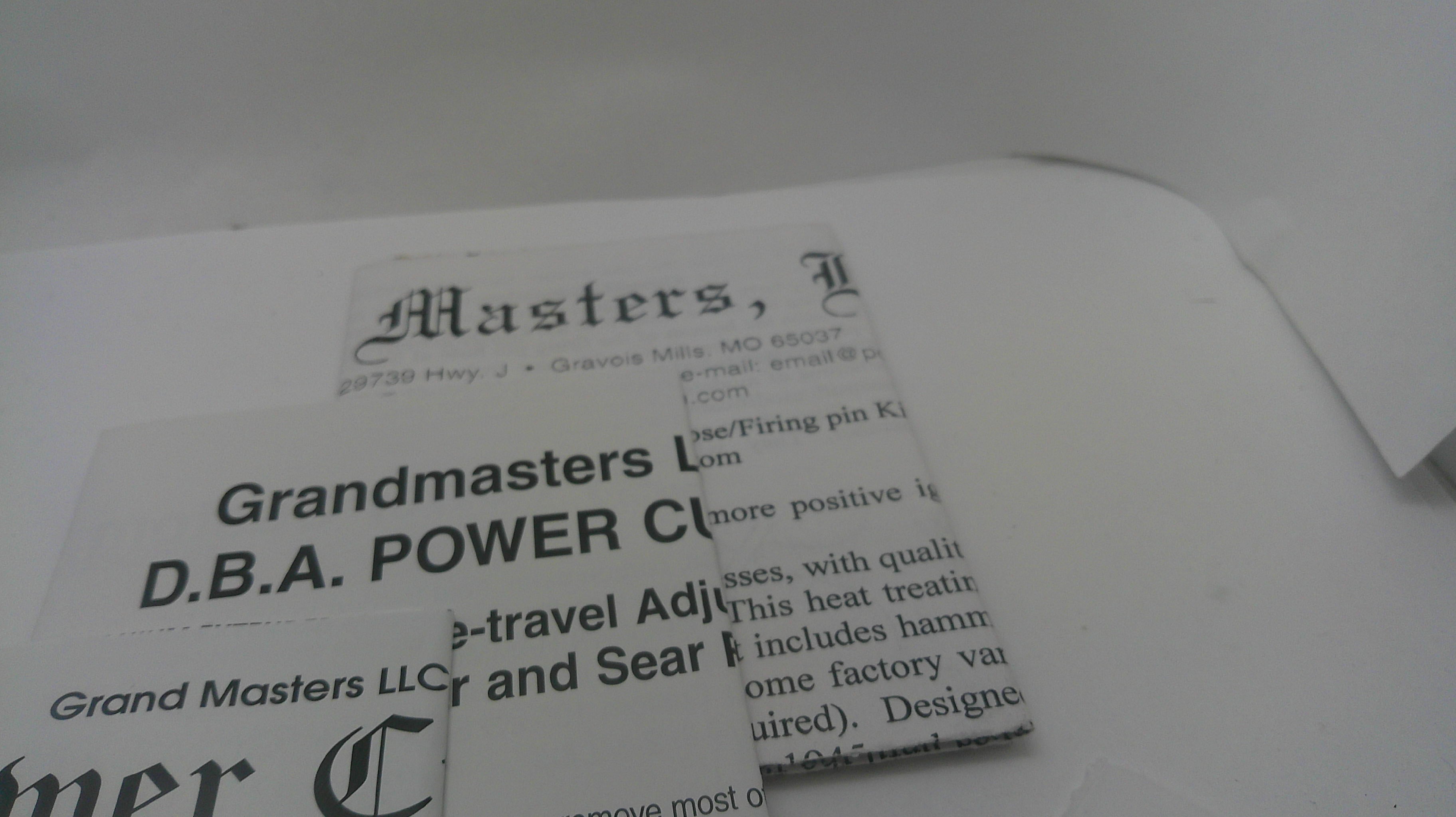A close-up of printed paper documents or labels with visible text including 'Masters,' 'Grandmasters,' and 'D.B.